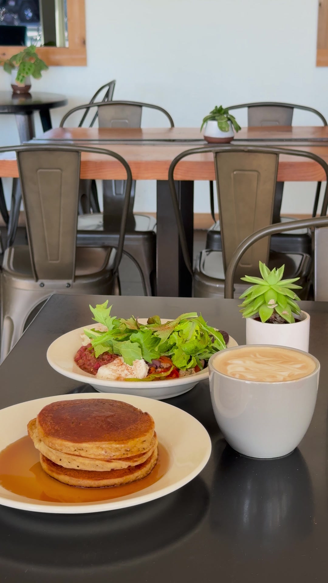 Pancakes, a salad and a latte on the table