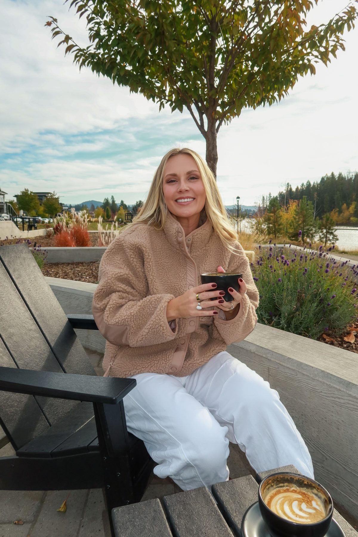 Kiana smiling with a coffee on the DOMA patio