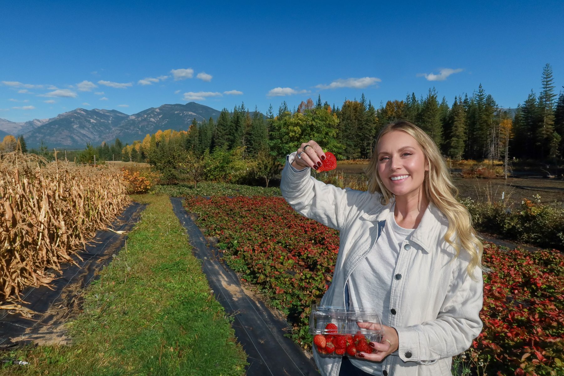 Kiana holding up fresh strawberries in the field