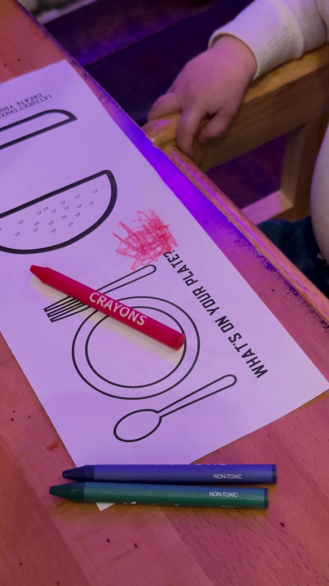 A kids’ coloring placemat with crayons
