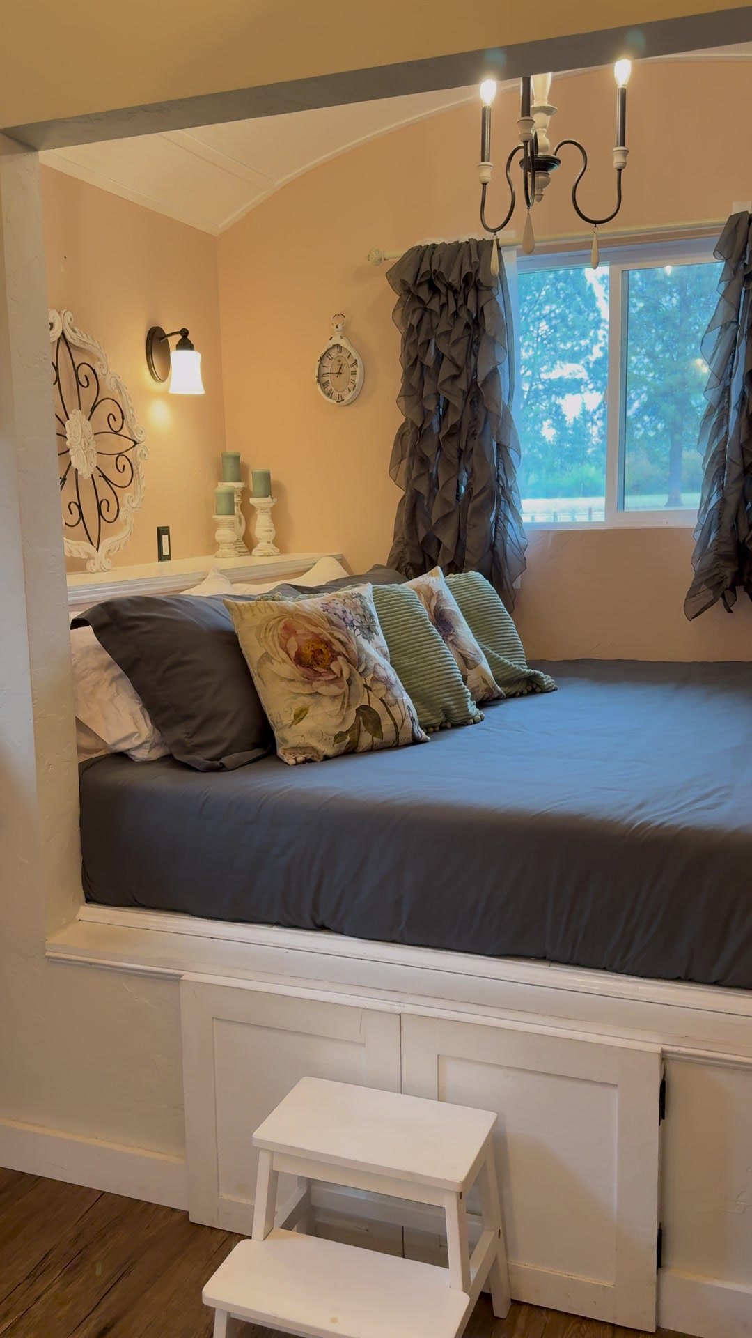 The bed nook with plaid pillows under the window